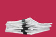 A stack of papers with paper clips, office folders on a carmine red background.