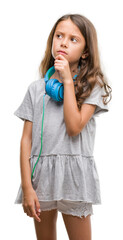 Poster - Brunette hispanic girl wearing headphones serious face thinking about question, very confused idea