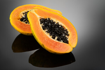 Poster - Papaya fruit on black background. Fresh organic Papaya exotic fruits close up. Healthy vegan papayas 