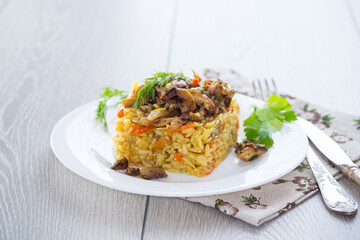 Wall Mural - Diet pilaf with mushrooms and vegetables in a plate .