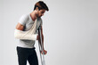 A man with a broken arm in a cast on crutches on a white background. ai generative