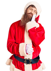 Poster - Handsome young red head man with long beard wearing santa claus costume thinking looking tired and bored with depression problems with crossed arms.