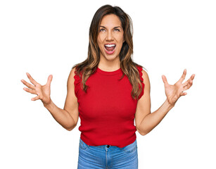 Poster - Young hispanic woman wearing casual clothes crazy and mad shouting and yelling with aggressive expression and arms raised. frustration concept.