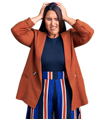 Wall Mural - Young beautiful brunette woman wearing elegant clothes suffering from headache desperate and stressed because pain and migraine. hands on head.