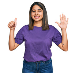 Wall Mural - Young hispanic girl wearing casual purple t shirt showing and pointing up with fingers number six while smiling confident and happy.