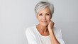 © Concept Island - Beautiful mature woman in her 50s with short gray hair and perfect skin, looking at the camera smiling, isolated on white background