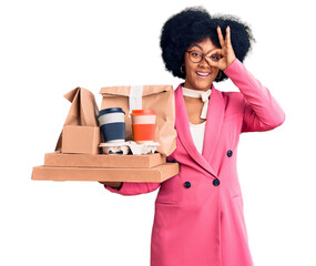 Poster - Young african american girl wearing business clothes holding delivery food smiling happy doing ok sign with hand on eye looking through fingers