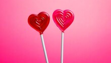 Two Pink And Red Polished Heart Shaped Red Lollipops On Pastel Pink Background