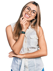 Poster - Hispanic young woman wearing casual white shirt looking confident at the camera with smile with crossed arms and hand raised on chin. thinking positive.