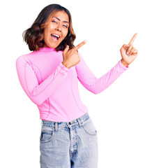 Wall Mural - Young beautiful mixed race woman wearing pink shirt smiling and looking at the camera pointing with two hands and fingers to the side.