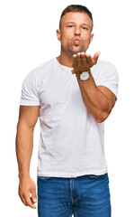 Poster - Handsome muscle man wearing casual white tshirt looking at the camera blowing a kiss with hand on air being lovely and sexy. love expression.