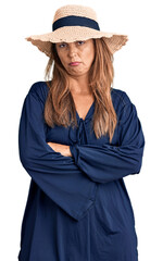 Poster - Middle age hispanic woman wearing summer hat skeptic and nervous, disapproving expression on face with crossed arms. negative person.