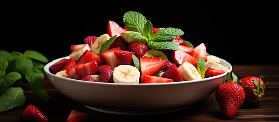 Wall Mural - Fruit salad featuring strawberries, bananas, and mint.