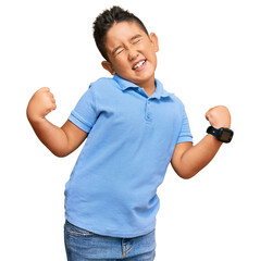 Sticker - Little boy hispanic kid wearing casual clothes very happy and excited doing winner gesture with arms raised, smiling and screaming for success. celebration concept.