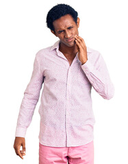 Canvas Print - African handsome man wearing casual pink shirt touching mouth with hand with painful expression because of toothache or dental illness on teeth. dentist