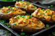 Closeup few baked potatoes stuffed with chicken, green onions and cheddar cheese on baking tray