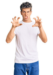 Wall Mural - Young handsome man wearing casual white tshirt smiling funny doing claw gesture as cat, aggressive and sexy expression