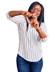 Sticker - Young african american woman wearing casual clothes and glasses smiling in love doing heart symbol shape with hands. romantic concept.