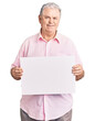© Krakenimages.com - Senior grey-haired man holding blank empty banner looking positive and happy standing and smiling with a confident smile showing teeth