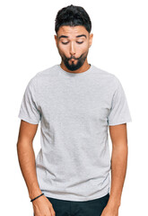 Poster - Young man with beard wearing casual grey tshirt making fish face with lips, crazy and comical gesture. funny expression.