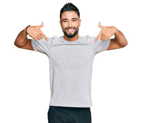 Canvas Print - Young man with beard wearing casual grey tshirt looking confident with smile on face, pointing oneself with fingers proud and happy.