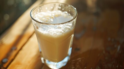 Canvas Print - A glass of milk sitting on top of a wooden table. Perfect for food and beverage related projects