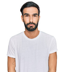 Wall Mural - Young hispanic man wearing casual white t shirt depressed and worry for distress, crying angry and afraid. sad expression.