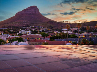 Wall Mural - Lion's Head after sunset with solar panels on the roof reflecting the sunset sky, Cape Town, South Africa