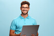 Man in blue shirt holding laptop. Suitable for technology, business, and communication themes.