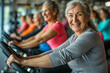 © v.senkiv - A smiling, happy, healthy, slim, elderly woman with graying hair is exercising in a gym with a group of people on an exercise bike