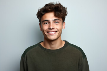 Wall Mural - Young man with curly hair smiling at camera. Perfect for portraits and lifestyle images.