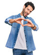 © Krakenimages.com - Young hispanic man wearing casual clothes smiling in love doing heart symbol shape with hands. romantic concept.