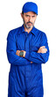© Krakenimages.com - Middle age handsome man wearing mechanic uniform skeptic and nervous, disapproving expression on face with crossed arms. negative person.