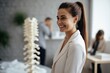 A Professional Chiropractor Woman in Her Modern Clinic, Smiling Warmly While Holding a Spinal Model, Demonstrating Her Expertise and Passion for Her Job