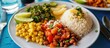 Typical Costa Rican dish with rice, beans, and vegetables on a blue tablecloth is called Casado.