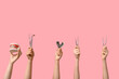 © Pixel-Shot - Female hands with dental tools and jaw model on pink background