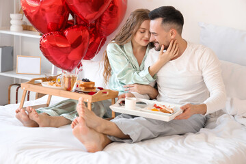 Poster - Happy young couple having breakfast in bed on Valentine's Day