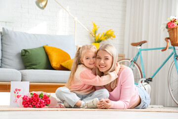 Canvas Print - Little girl hugging her mother at home. International Women's Day celebration