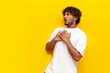 © Богдан Маліцький - shocked young indian man looking away scared and surprised on yellow isolated background, excited guy surprised and amazed in fear