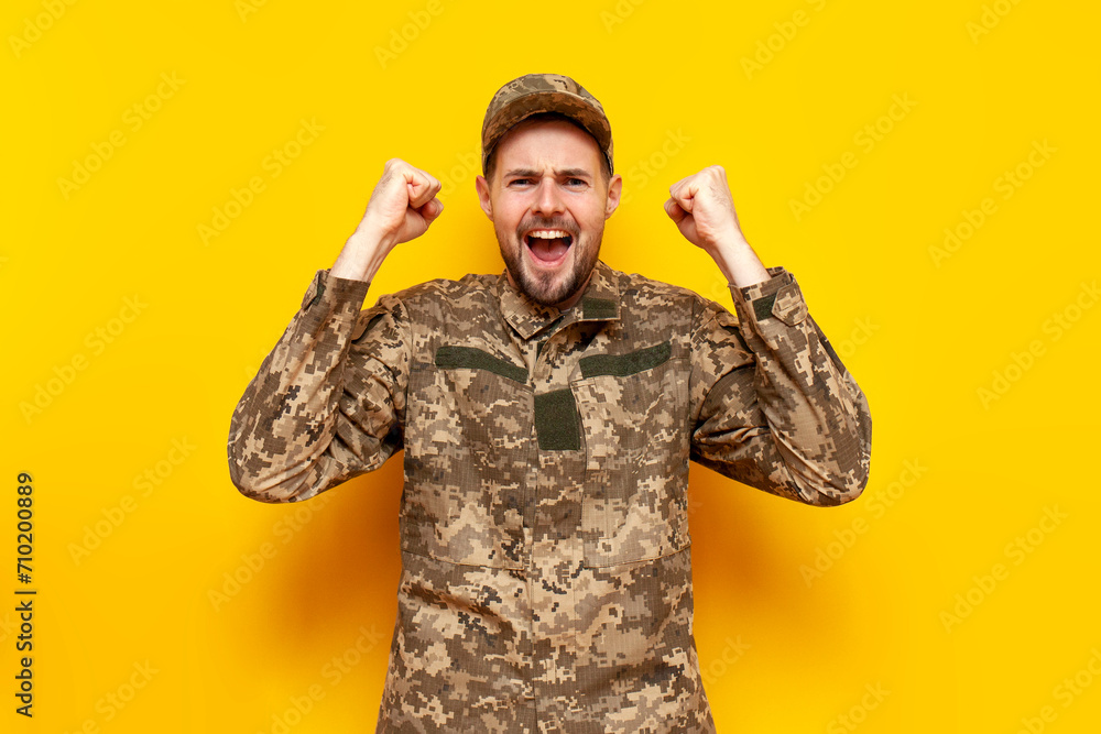 young Ukrainian male soldier in pixel camouflage uniform celebrates ...