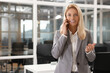 © New Africa - Smiling woman talking on smartphone in office, space for text. Lawyer, businesswoman, accountant or manager