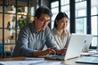 © Lumina Frame - Two busy diverse professional coworkers discussing work using laptop in office. Asian employee learning online project discussing business plan with mature manager looking at computer, Generative AI