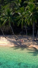 Wall Mural - Koh Wai Island Trat Thailand near Koh Chang. wooden bamboo hut bungalow on the beach and a young couple of men and woman walking at the beach on a tropical Island in Thailand