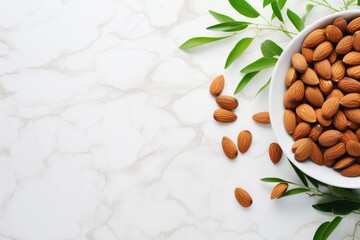 Wall Mural - Delicious almonds and fresh leaves on white table Flat lay with space for text