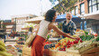 © Gorodenkoff - Cheerful Street Vendor Running a Small Farm Market Business, Selling Sustainable Fruits and Vegetables. Happy Middle Aged Man Filling a Recycled Paper Shopping Bag with Local Natural Food