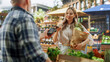 © Gorodenkoff - Modern Female Shopper Using Smartphone with Contactless Payment Technology to Pay for Organic Vegetables at a Farmers Market. Street Vendor Holding an Electronic Online Payment Terminal Device