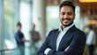 © Farnaces - Portrait of a handsome smiling asian indian businessman boss standing in his modern business company office.