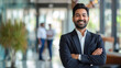 © Farnaces - Portrait of a handsome smiling asian indian businessman boss standing in his modern business company office.