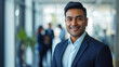 © Farnaces - Portrait of a handsome smiling asian indian businessman boss standing in his modern business company office.