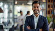 © Farnaces - Portrait of a handsome smiling asian indian businessman boss standing in his modern business company office.